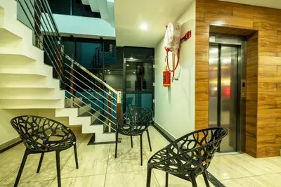 a staircase with three chairs and a stair case at Daan Regency in Trichūr