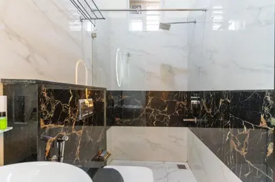 a bathroom with a black and white marble wall at Sree Bharat Residency in Alāndurai
