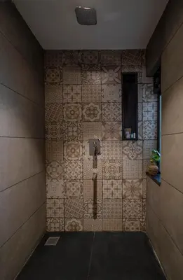 a bathroom with a tiled wall with a shower istg at Klov Resort & Spa in Wayanad