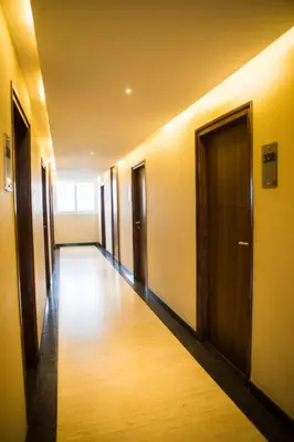 a hallway with a row of doors in a building at Samasth Palatial in Mysore