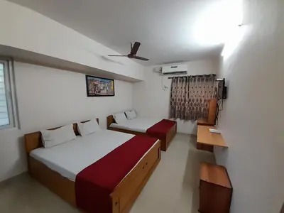 a small bedroom with two beds and a window at SUPREME RESIDENCY in Coimbatore