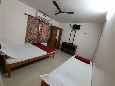 a bedroom with two beds and a ceiling fan at SUPREME RESIDENCY in Coimbatore