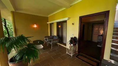 a living room with a yellow wall and a door at Fireflies Kabini in Begūr