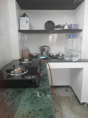 a kitchen with a stove top oven in a room at WHITE HOUSE- 1BK Pleasant Apartment with Open Terrace in Coimbatore