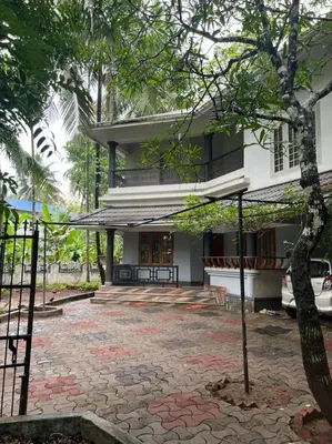 a house with a stone walkway in front of it at H Villa in Nilambūr