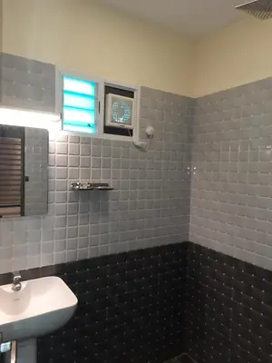 a bathroom with a white sink and a window at Emerald Royal Residency in Cochin
