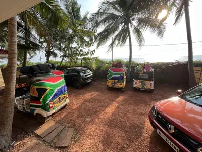 a group of cars parked next to palm trees at Kizhunna rock beach house in Kannur