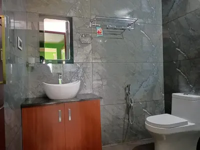 a bathroom with a sink and a toilet and a mirror at Agronest Farm by LivingStone in Sultan Bathery