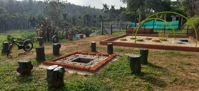a garden with a fire pit in the grass at Agronest Farm by LivingStone in Sultan Bathery
