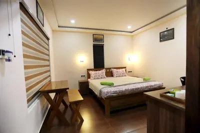a small bedroom with a bed and a desk at Agronest Farm by LivingStone in Sultan Bathery