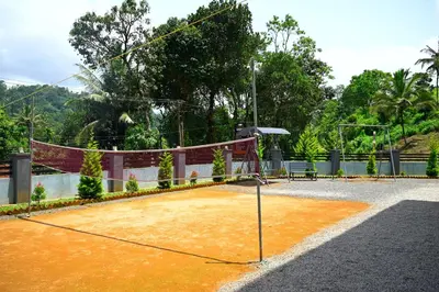 a tennis court with a net on top of it at Besrauma Vythiri in Vythiri