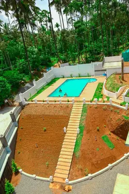 a large garden with a swimming pool in it at Besrauma Vythiri in Vythiri