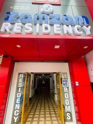 a sign for a car retailer in front of a building at Zam Zam Residency in Cheruppulasseri