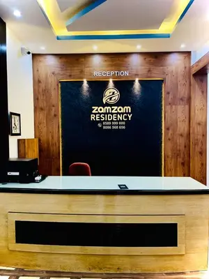 a reception desk with a sign for a restaurant at Zam Zam Residency in Cheruppulasseri