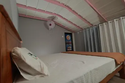 a bedroom with a bed and a ceiling fan at Babu's Homestay By Lexstays in Mananthavady