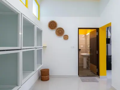 a bathroom with a yellow door and a sink at The Hosteller Coorg, Madikeri in Madikeri