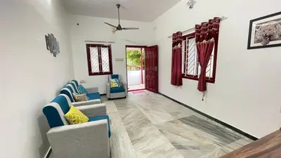 a living room with two chairs and a couch at WHITE HOUSE - 3BHK Elite Apartment in Coimbatore