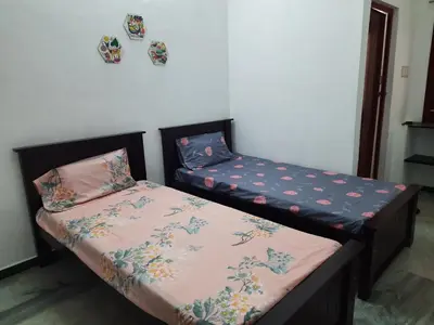 two beds sitting next to each other in a room at WHITE HOUSE - 3BHK Elite Apartment in Coimbatore