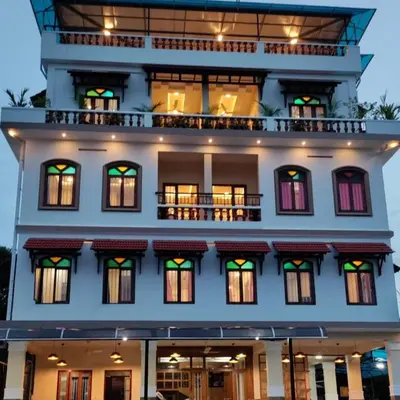a large white building with windows and a balcony at Meghdoot river resort in Ernakulam