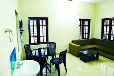 a living room with a couch and a table and chairs at Shibi's Tea Garden Heritage in Vayittiri