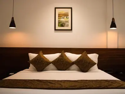 a bedroom with a white bed with four pillows at THE RUNWAY HOTEL in Cochin