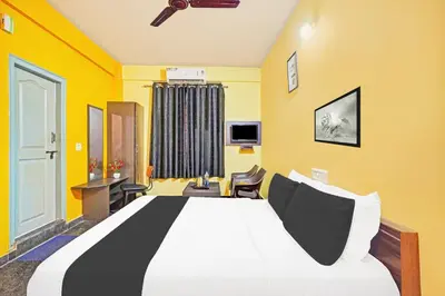a bedroom with a large bed with yellow walls at Super Collection O Coorg in Madikeri