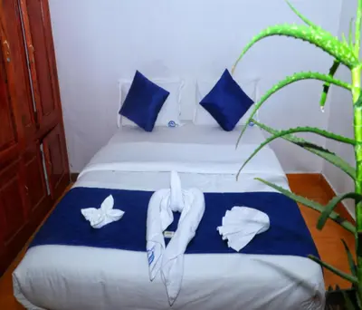a bedroom with a bed with blue and white pillows at AC MIST in Munnar