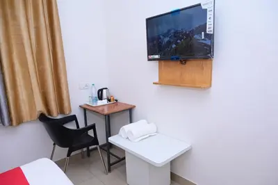 a room with a bed and a tv on the wall at Hotel Stay Shine in Mysore