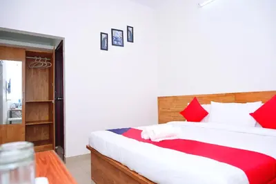 a bedroom with a large bed with red pillows at Hotel Stay Shine in Mysore