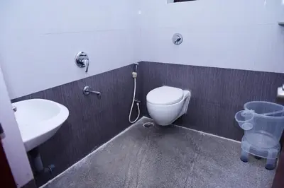 a bathroom with a toilet and a sink at Hotel Stay Shine in Mysore