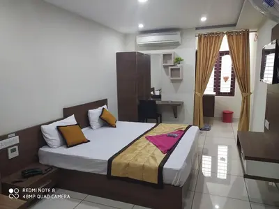 a bedroom with a bed and a desk in it at Kallada Residency in Perintalmanna