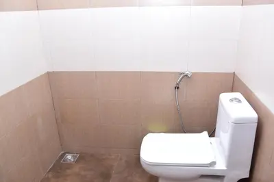 a bathroom with a white toilet and a shower at Pauls Retreat Wayanad , Family Resort in Wayanad