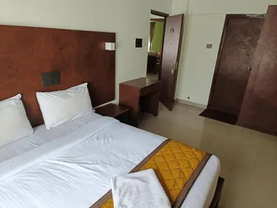 a bedroom with a large bed with a wooden headboard at PPH Living Athithi Inn Corporate Stay in Coimbatore