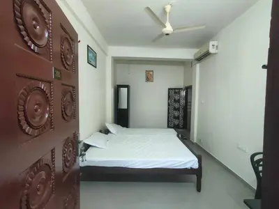a bedroom with a bed and a ceiling fan at Jinnens Tourist Home in Ponnāni