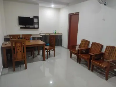 a dining room with a table and chairs and a tv at PMS Dhabi Residency in Kottakkal
