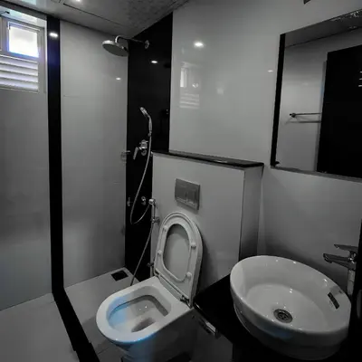 a small bathroom with a toilet and a sink at GDC - Apartment suites in Ernakulam