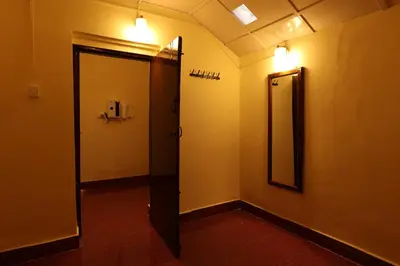 a bathroom with a door and a mirror on the wall at Avadale Coorg - Stag Groups Not Allowed in Ammatti