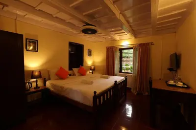 a bedroom with a large bed with red pillows at Avadale Coorg - Stag Groups Not Allowed in Ammatti