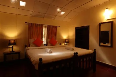 a bedroom with a large white bed with red pillows at Avadale Coorg - Stag Groups Not Allowed in Ammatti