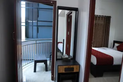a mirror in a room with a bed and a bedroom at NIDHI RESIDENCY in Guruvāyūr