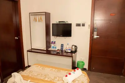 a hotel room with a bed and a television at THE PEBBLE Boutique Hotel in Tiruppūr