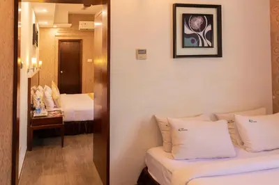 a room with two beds and a mirror at THE PEBBLE Boutique Hotel in Tiruppūr