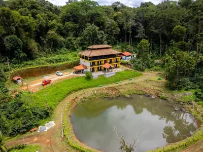 an aerial view of a house with a pond at The Hosteller Coorg Rainforest, Madikeri in Madikeri