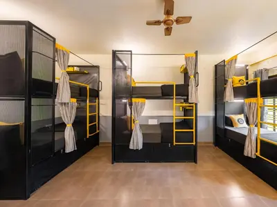 a room with three bunk beds and a ceiling at The Hosteller Coorg Rainforest, Madikeri in Madikeri