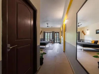 a hallway with a door and a living room at The Hosteller Coorg Rainforest, Madikeri in Madikeri