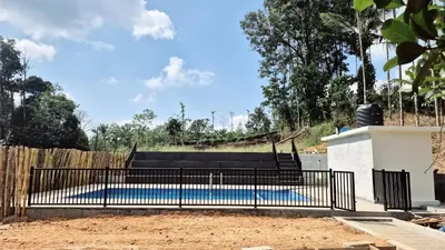 a fence around a swimming pool in a yard at Perya Hills in Periya