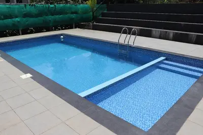 a swimming pool with blue water in a yard at Perya Hills in Periya