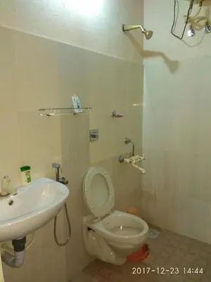 a bathroom with a toilet and a sink at Casa Riverdale Farm Stay in Vallikavungal