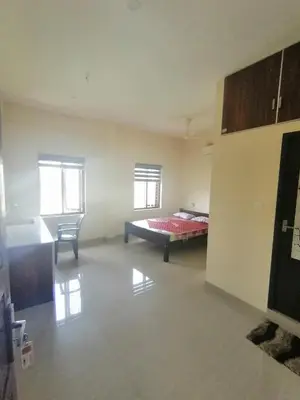 a large room with a bed and a chair in it at Queens Residency in Trichūr