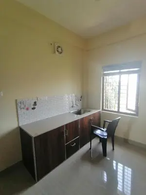 a kitchen with a sink and a chair in a room at Queens Residency in Trichūr